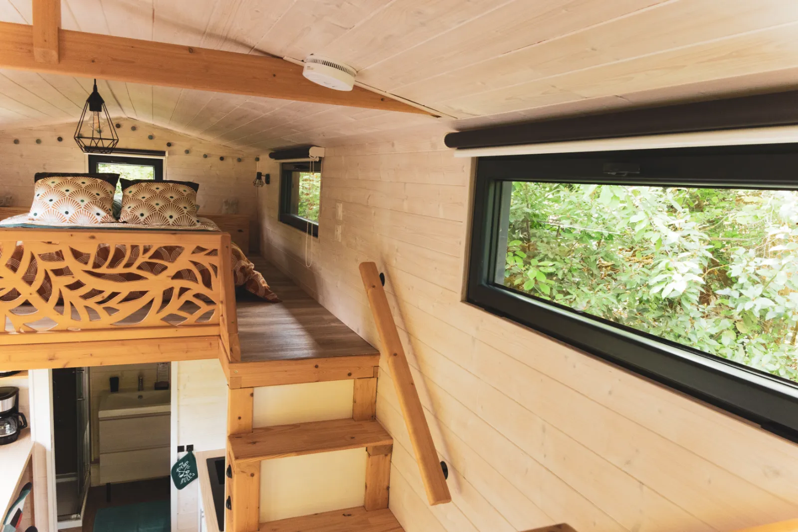 Jacuzzi extérieur en bois sur terrasse avec pergola, dans un jardin verdoyant